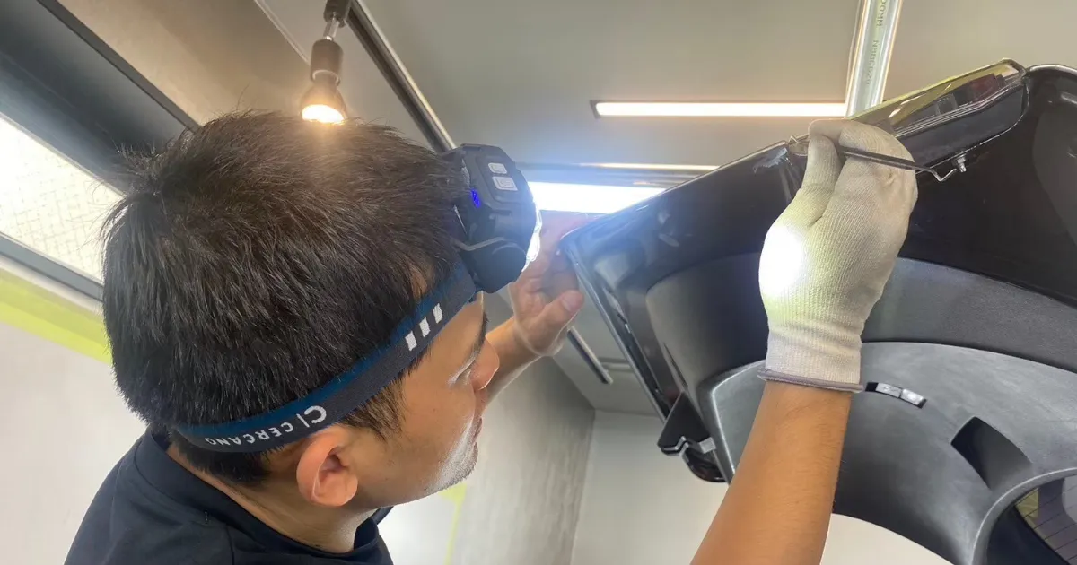 フィルムの端を丁寧に巻き込む作業