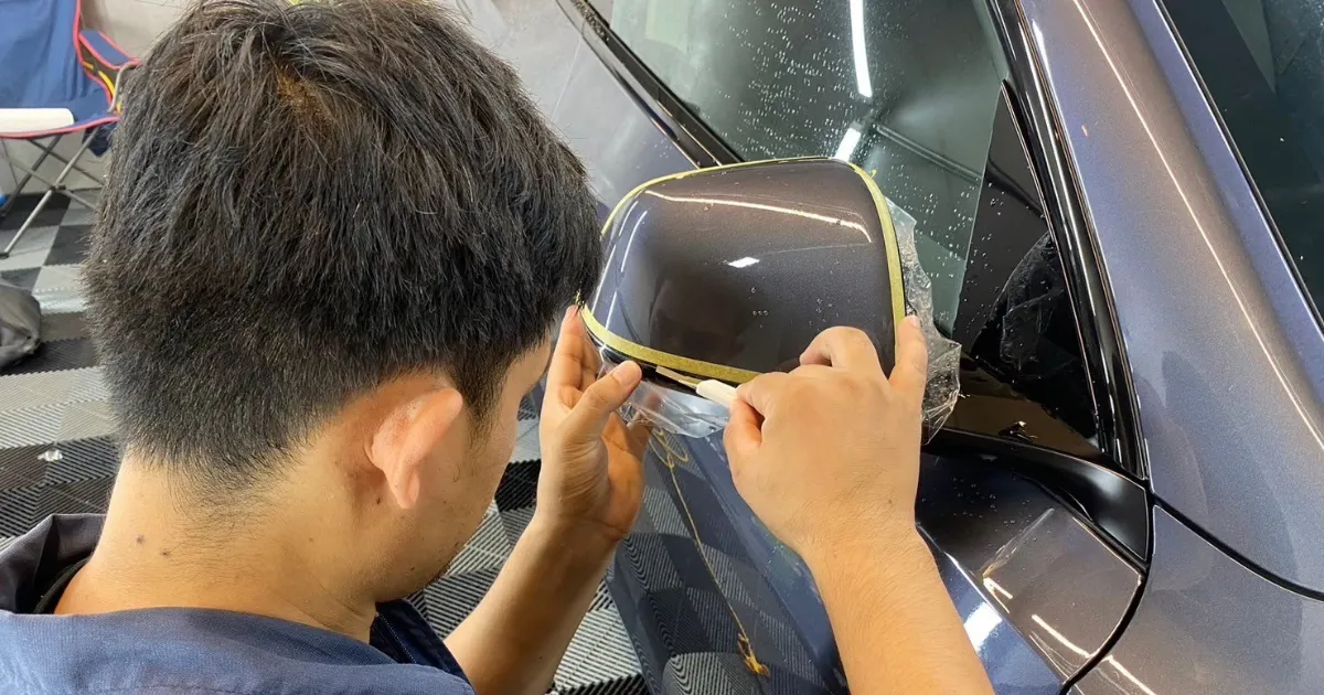 空調管理された清潔な屋内ピットでマットブラックのテスラを施工する様子