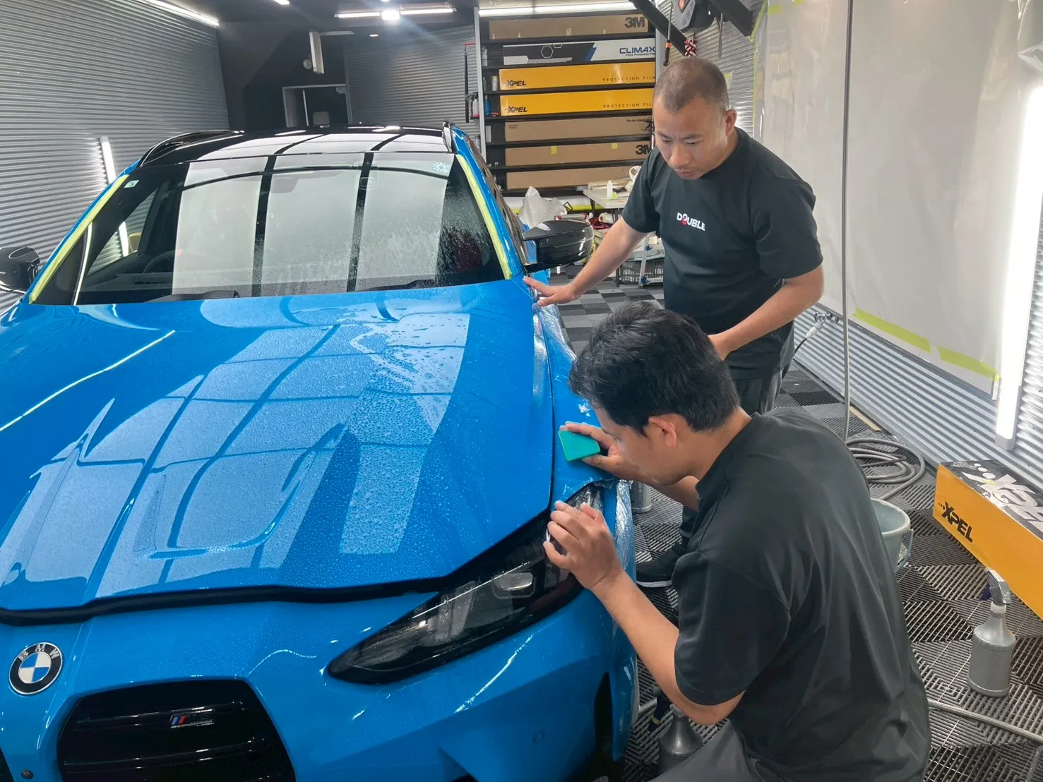 フロントバンパー周辺の2名体制での仕上げ作業